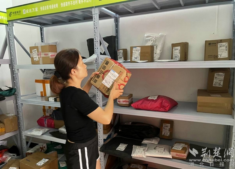 在城北街道西十村寄遞物流綜合便民服務(wù)站，站點負(fù)責(zé)人正在對快遞包裹進行分類擺放  攝 余新怡攝.jpg