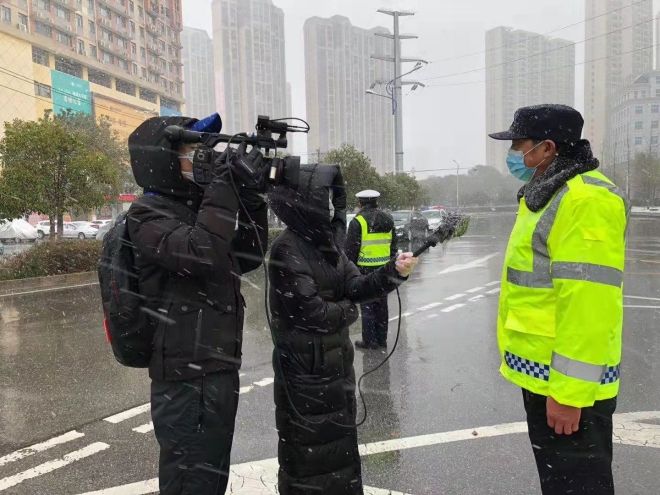 孝感市融媒體中心楊亞玲（風(fēng)雪中，采訪疫情期間重返一線的退休警察）_副本.jpg.jpg